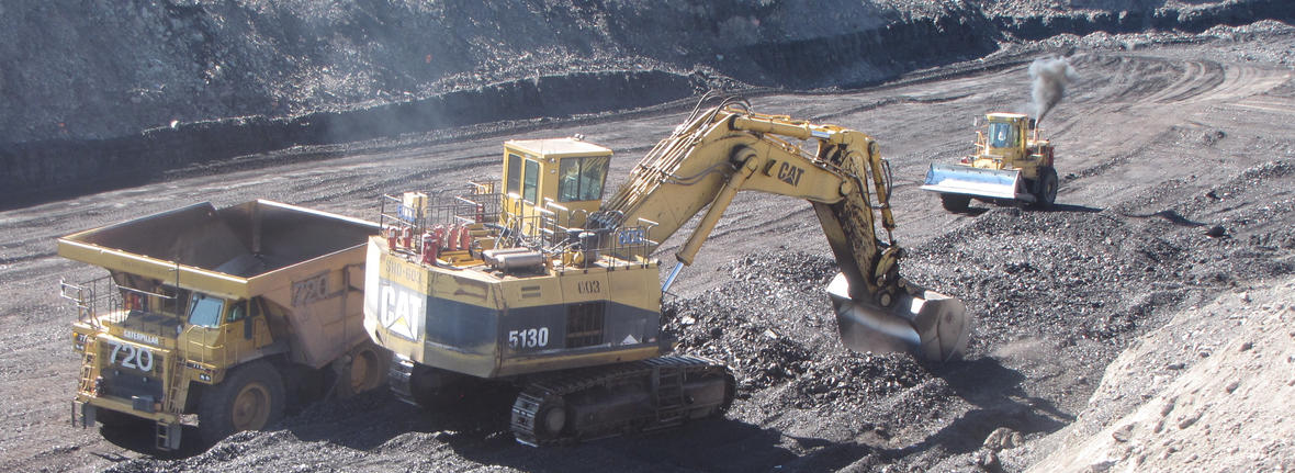 Image shows coal being loaded into trucks at a coal mine